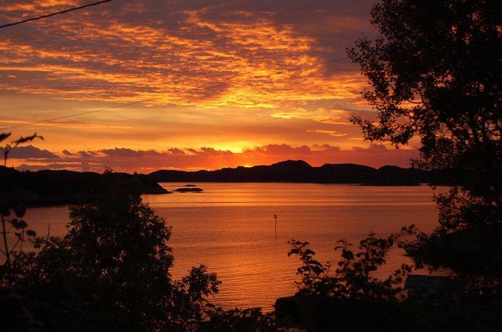 Oransje solnedgang over sjø og holmar - Klikk for stort bilete